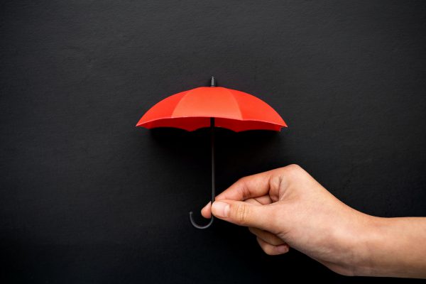 Hand hold a small red umbrella for protection concept